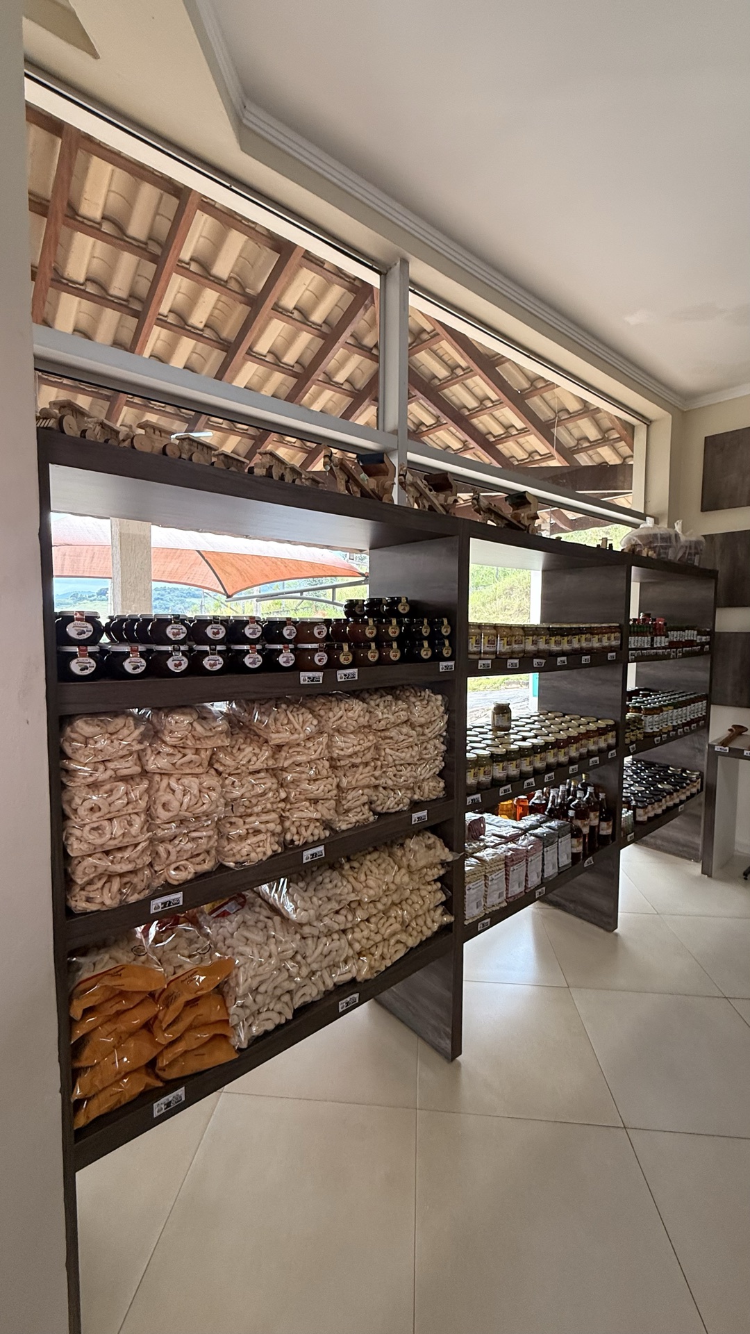 Prateleiras laterais do empório com biscoitos, doces e conservas regionais