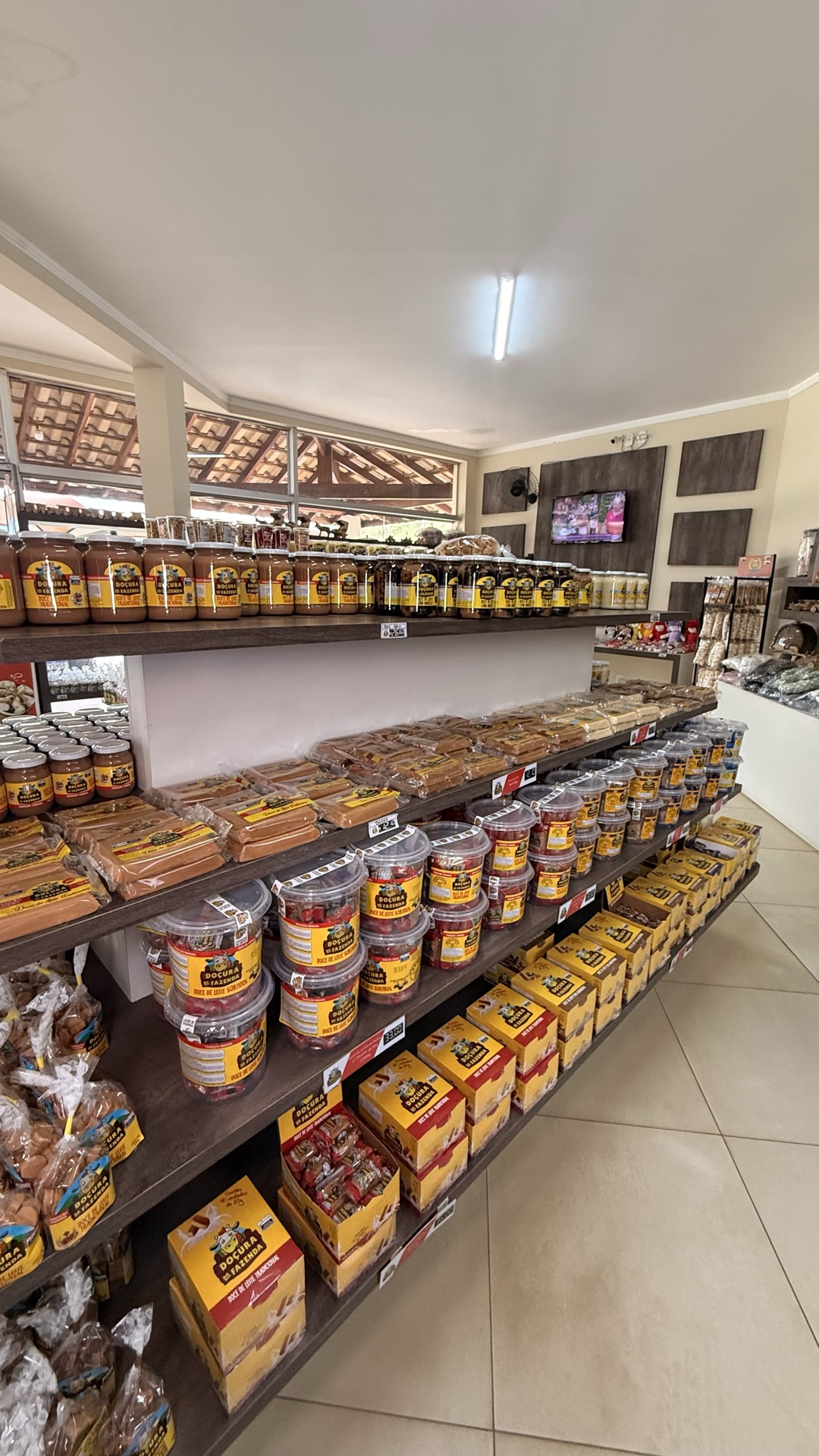 Prateleira central do empório com doces de leite, saquinhos e potes organizados