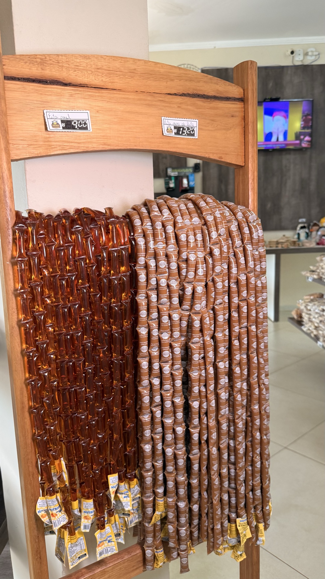 Detalhe de doces e mel em expositor de madeira dentro do empório